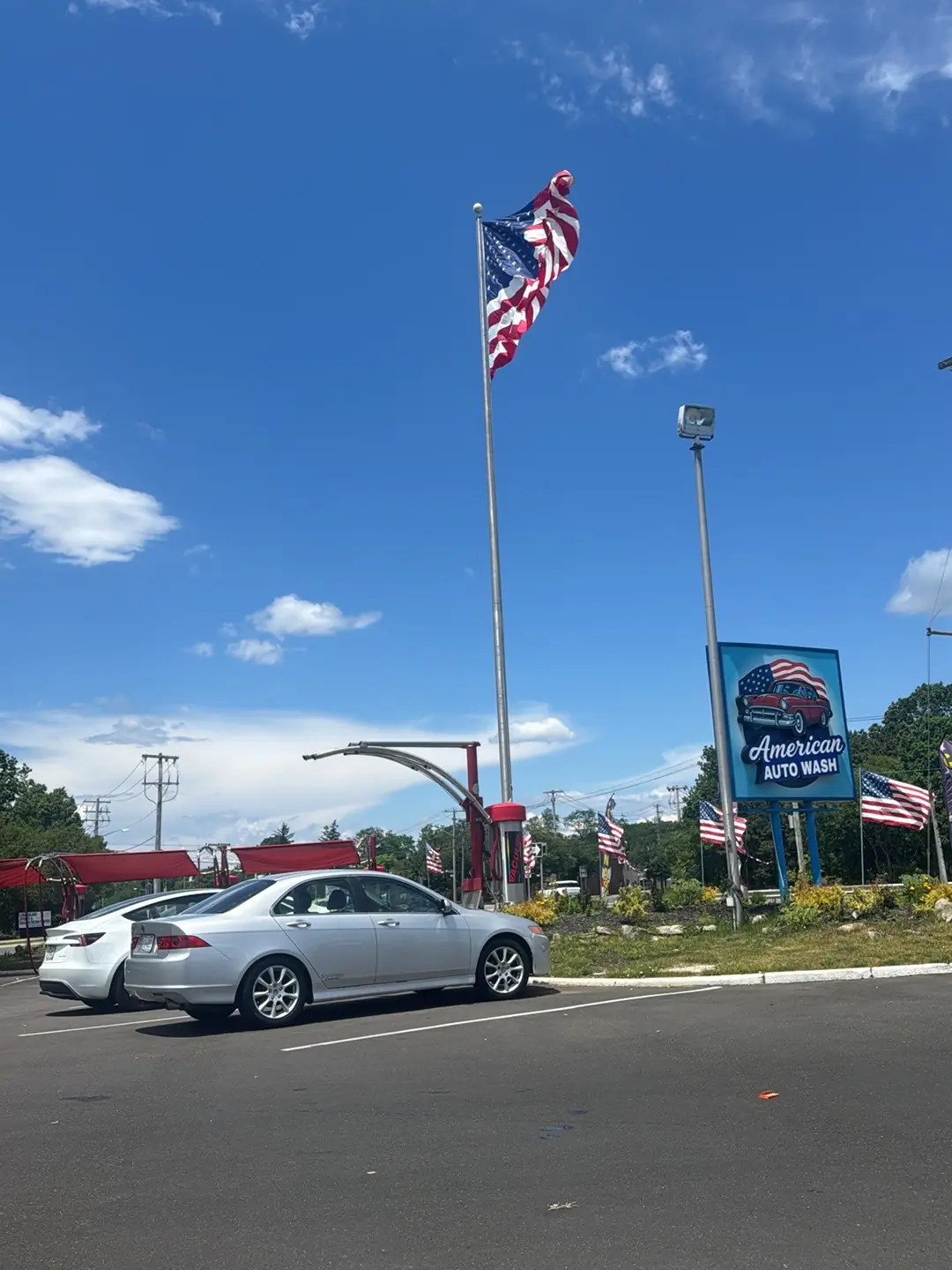 The American Auto Wash sign and the American flag over Veterans Memorial Highway