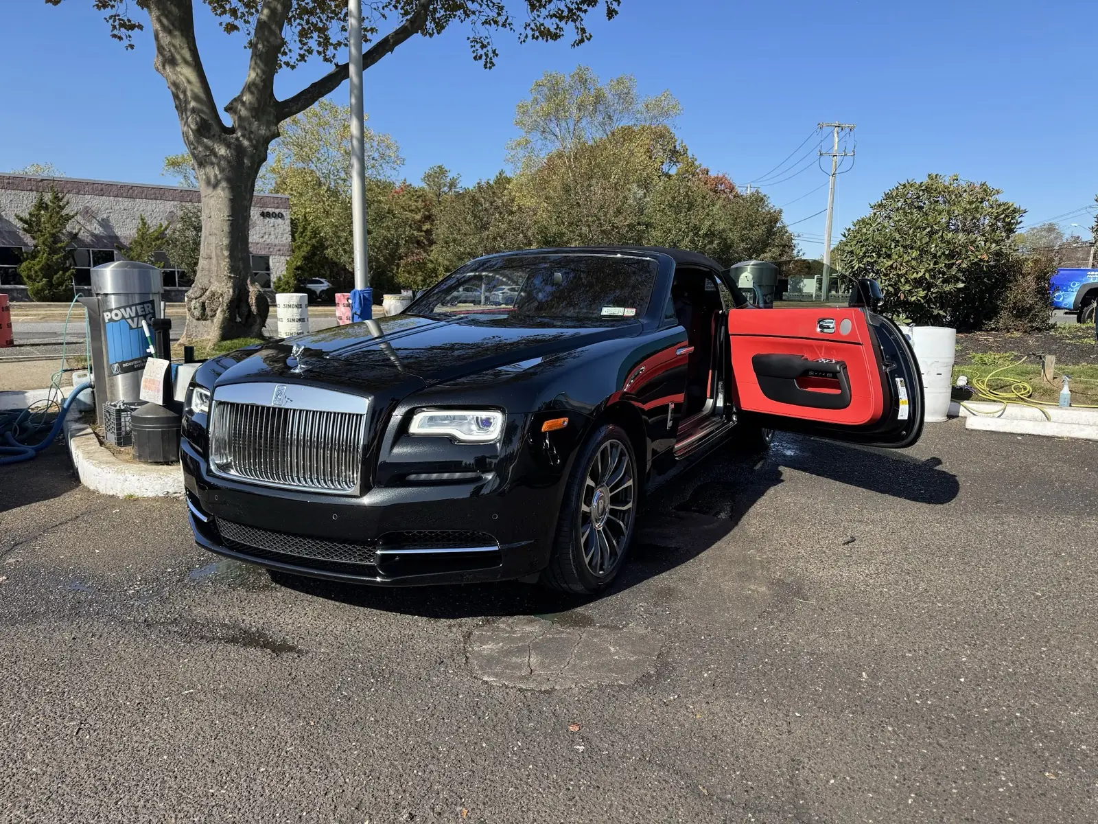 A black Rolls-Royce with red leather interior at American Auto Wash